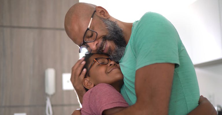 Photo d'un père prenant son fils dans ses bras