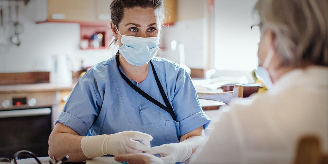 personnel soignant avec masque et blouse bleue