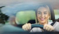 femme avec le sourire au volant d'une voiture 