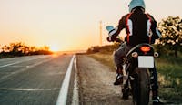 Homme sur la moto au coucher du soleil