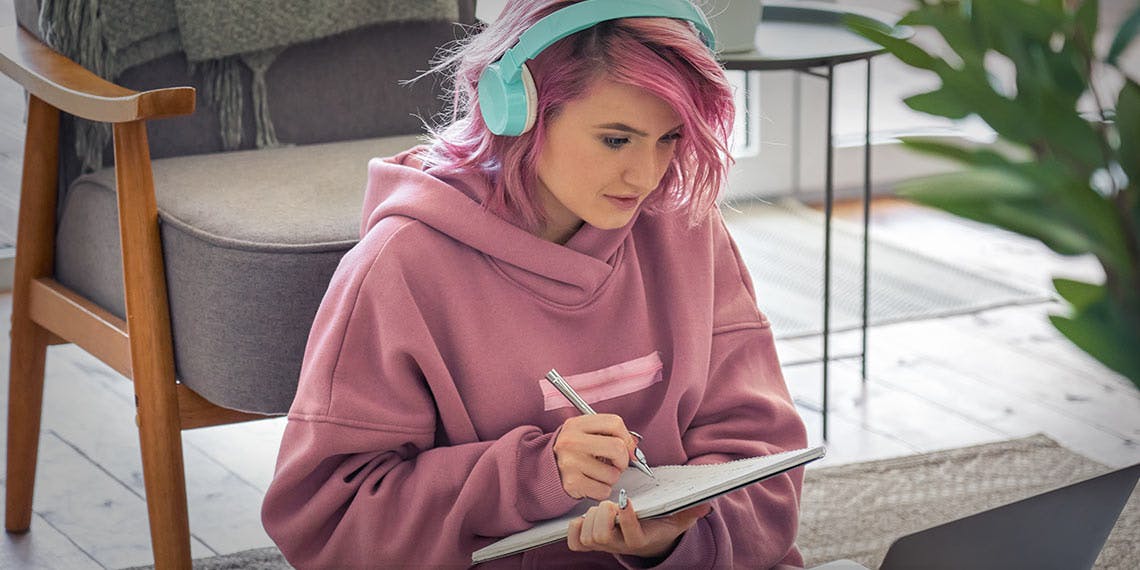 jeune fille ado etudiante avec cahier devant ordinateur portable