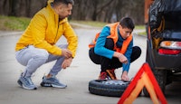 deux hommes en train de changer pneu crevé