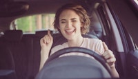 Jeune femme joyeuse dans une voiture